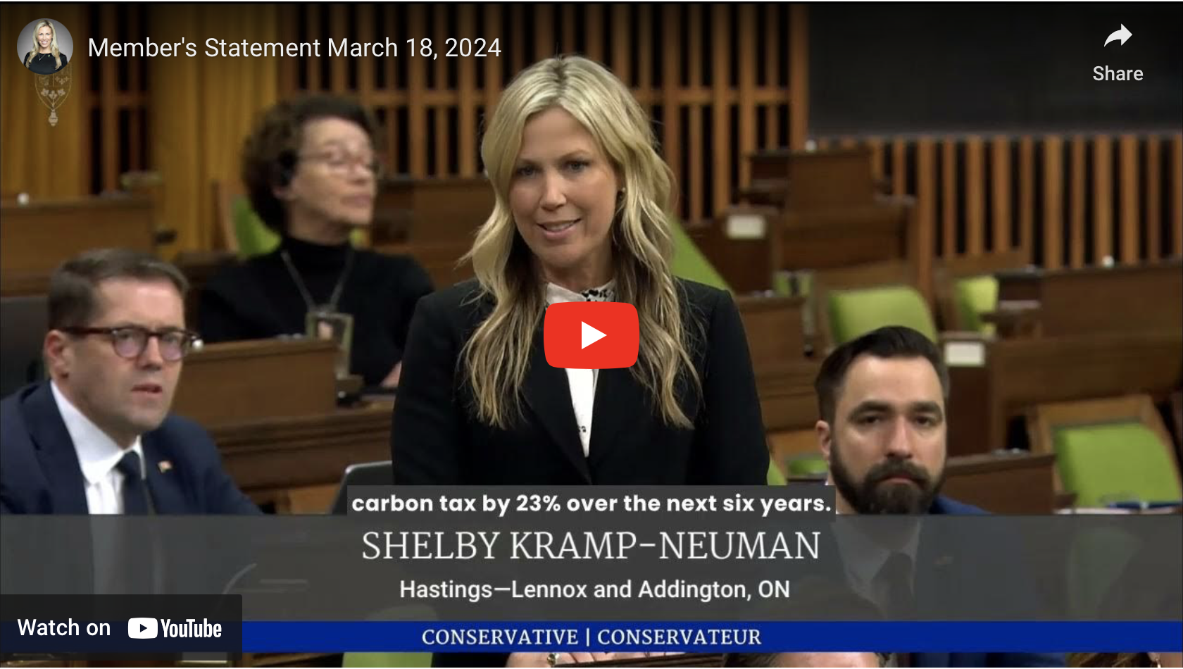 Shelby speaking in the House of Commons with a black jacket and white top.
